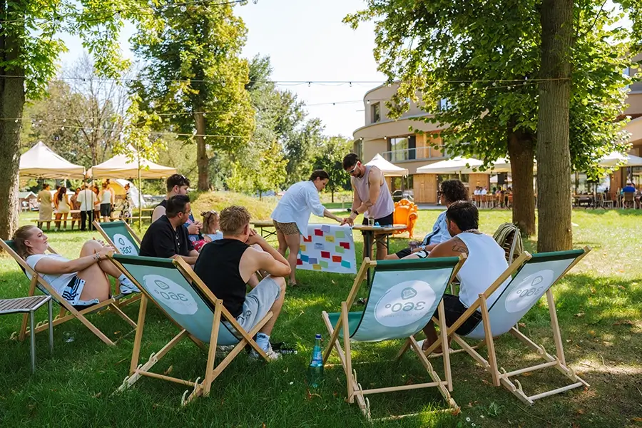 Menschen sitzen auf Strandstühlen beieinander.